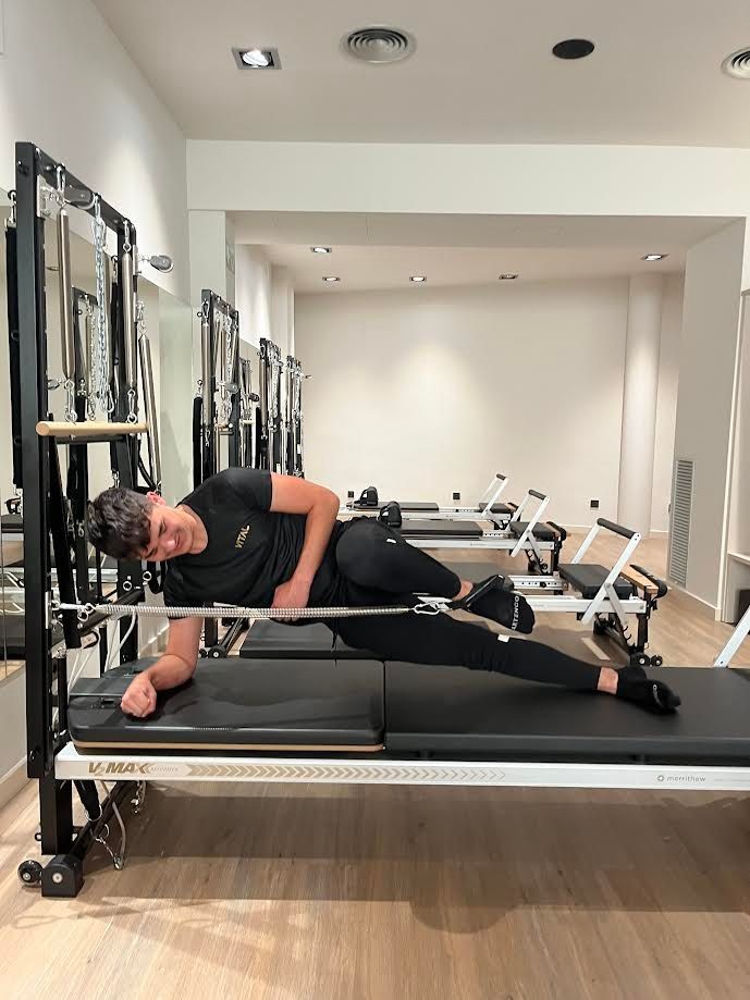 Chico haciendo pilates reformer en clase individual